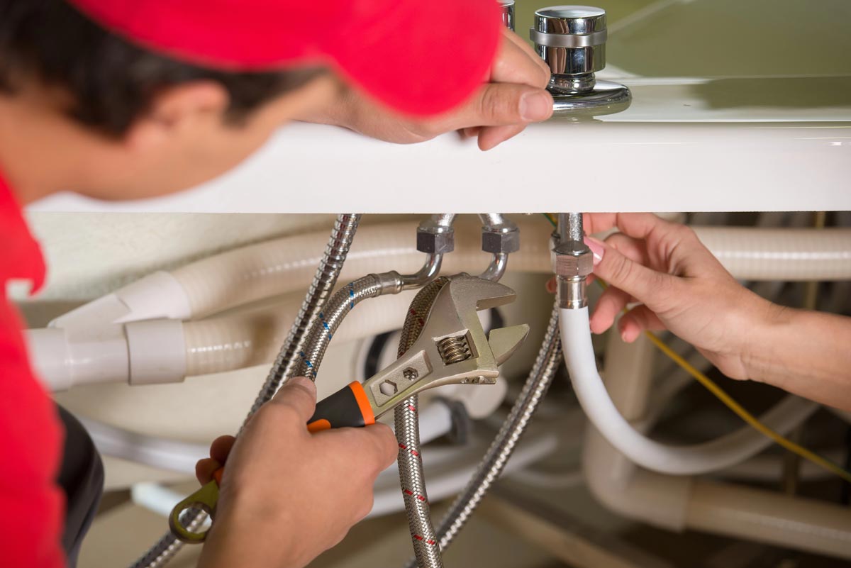 Professional plumber inspecting residential plumbing in a home